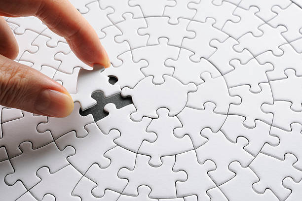 Holding a red final piece of the jigsaw against black background. Holding a red final piece of the jigsaw against black background.